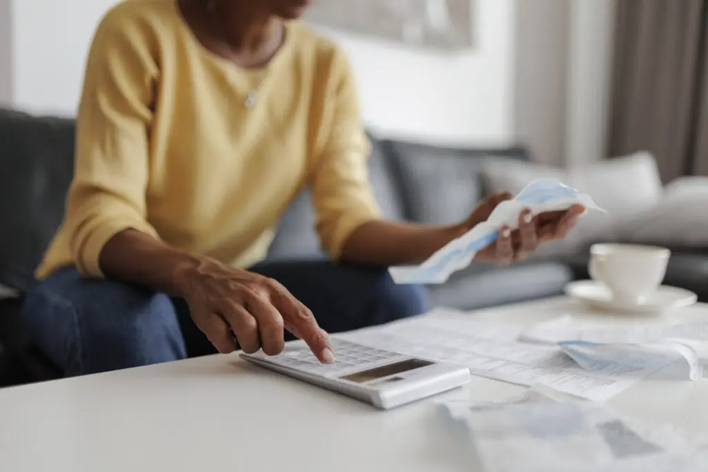 Budgeting with bills and calculator on table