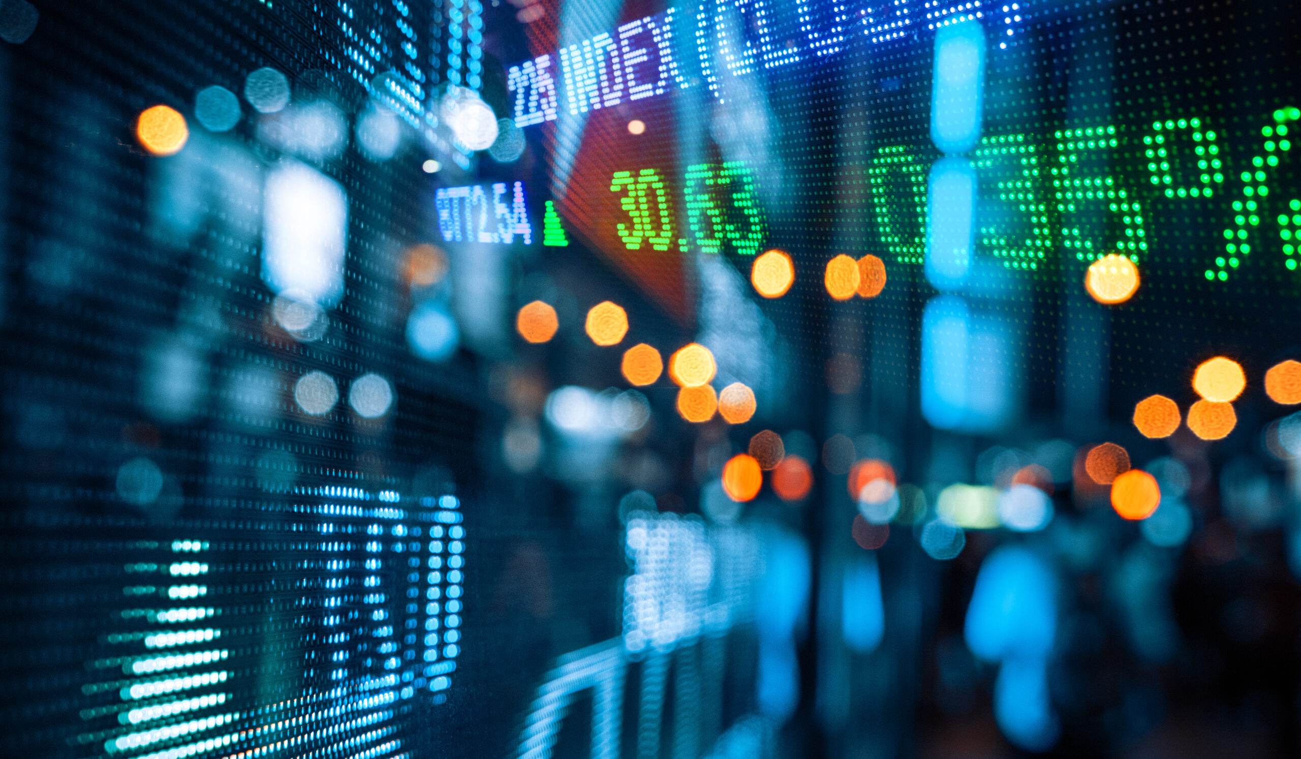 Blurred city lights and stock exchange board