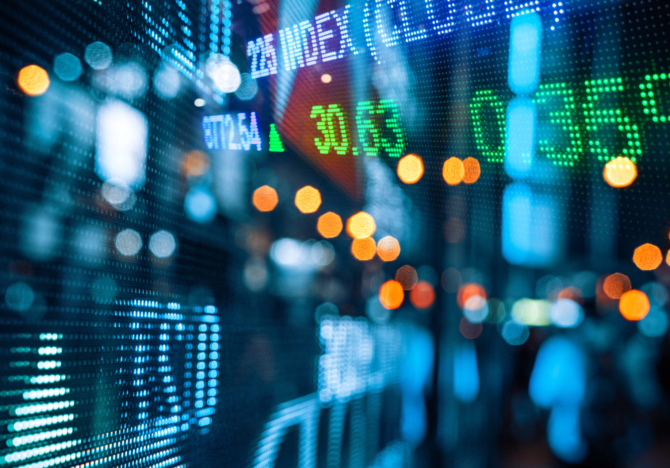 Blurred city lights and stock exchange board